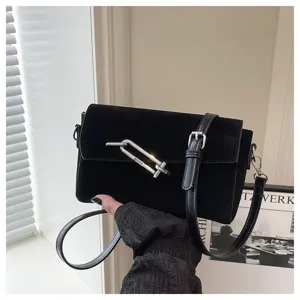 Detailed close-up of a black velvet shoulder bag with unique silver metal hardware lock design.
