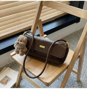 Trendy brown patent leather baguette shoulder bag with cute bear pendant for women winter fashion