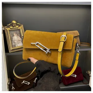 Mustard yellow suede crossbody bag with distinctive metal lock detail, chic shoulder purse.