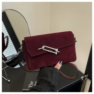 Burgundy suede shoulder bag for women, stylish crossbody bag with metal lock and strap.
