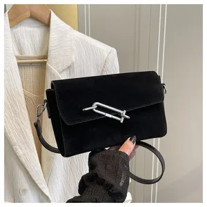 Black suede crossbody bag with distinctive metal clip closure, stylish casual commuter shoulder bag.