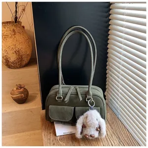 Vintage green suede shoulder bag with dual handles, front pockets and cute fluffy bunny charm.