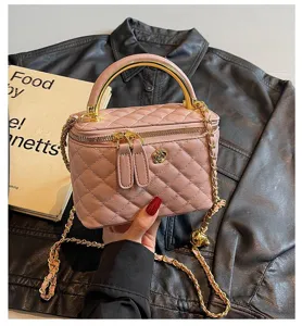 Pink quilted leather vanity handbag with metal top handle and stylish chain strap for women.