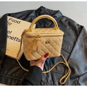 Beige quilted vanity bag with metal handle and chain strap, elegant chic crossbody bag.