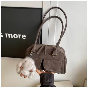 Retro vintage brown shoulder handbag with double straps, front pockets and plush charm.