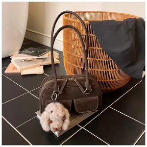 Retro brown shoulder bag detail shot featuring textured material, dual straps, and cute plush bunny charm.