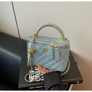 Blue quilted vanity handbag with gold handle, chain strap and camellia charm for women.