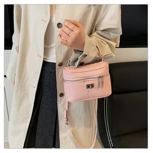 Close-up detail shot of the pink leather box handbag, featuring metal lock closure and strap.