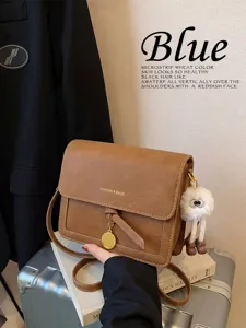 Retro brown crossbody shoulder bag with cute plush pendant, exquisite detail and vintage style.