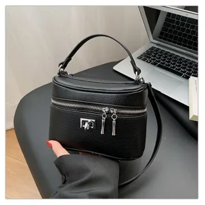 Black textured box bag detail, elegant top handle and metal lock. Perfect daily accessory.