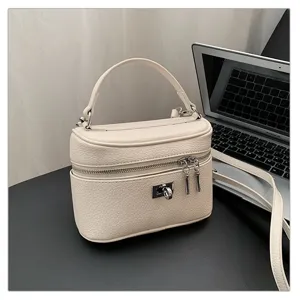 Stylish women's pebbled leather box handbag with top handle and chic turn-lock closure.