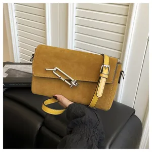 Detailed view of the stylish brown suede crossbody bag with metallic clasp and strap.