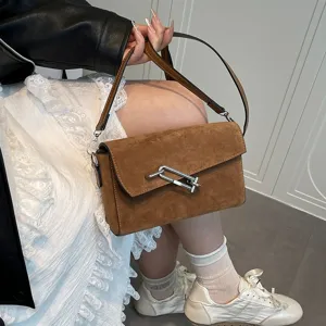 Brown suede shoulder bag for women, stylish crossbody bag with metal lock hardware and strap.