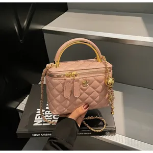 Chic pink quilted vanity bag with gold top handle and chain strap, elegant shoulder purse.