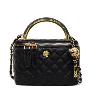 Black quilted leather vanity handbag with gold top handle and chain strap for women.