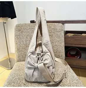 Vue détaillée du sac porté épaule en nylon léger, avec texture souple et grand espace.
