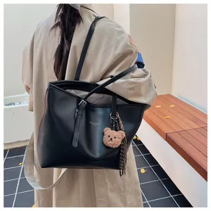 Grand sac cabas noir en cuir pour femme, élégant sac à main vintage avec pendentif ours.
