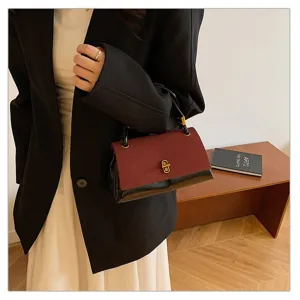 Detail shot of vintage colorblock handbag with chic metal lock and elegant flap design.