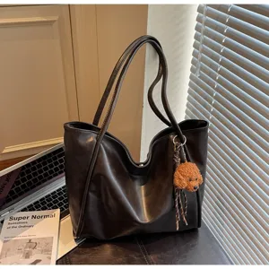 Vintage oil wax leather tote bag detail view, large capacity shoulder handbag with cute plush charm.