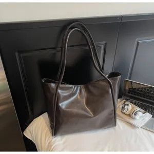 Dark brown oil wax leather shoulder tote bag detail view, casual commute handbag showcase.
