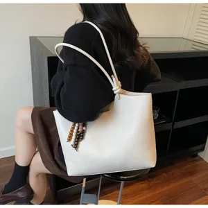 Detail view of minimalist vintage white tote bag worn by model, showcasing premium texture.