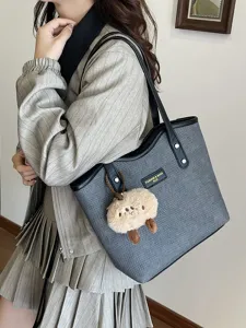 Detail view of casual women tote bag with plush pendant, stylish commuting shoulder bag.