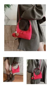 Red suede hobo shoulder bag for women, stylish minimalist handbag with cute fluffy charm pendant.