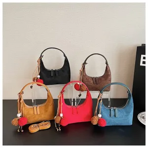 Suede dumpling hobo shoulder bag detail showcasing multiple colors, plush charms and straps.