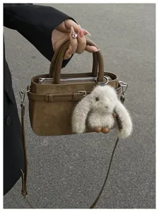 Chic brown PU leather shoulder handbag with cute fluffy bunny charm for daily commute.