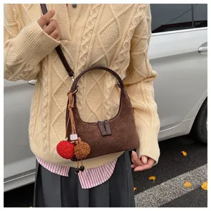 Brown suede hobo dumpling bag for women, vintage autumn shoulder crossbody bag with pom-pom charm.