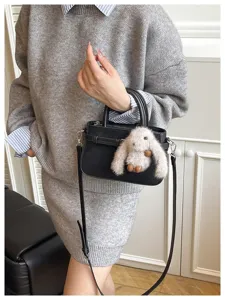 Chic black shoulder handbag for women, elegant commuter messenger bag with cute bunny charm.