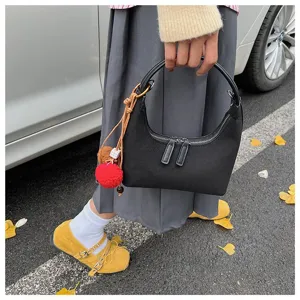 Black suede dumpling handbag detail showing texture and zipper design for autumn and winter.