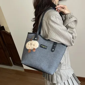 Grey PU tote bag detail view, casual commuter shoulder bag with cute plush sheep pendant.