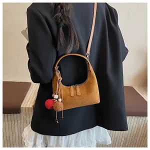 Brown suede dumpling shoulder bag detail showcasing retro design with plush charm accent.
