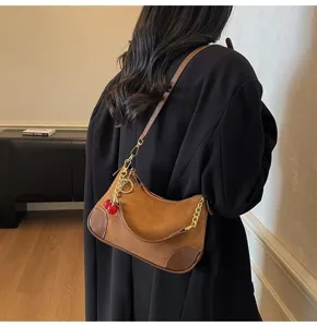 Vintage brown suede PU shoulder bag with stylish cherry charm and chain detail for women.