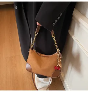 Vintage brown suede PU shoulder bag detail showing stylish cherry charm and gold chain.