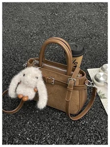 Brown commuter shoulder bag with fluffy bunny pendant, stylish autumn winter handbag for women.