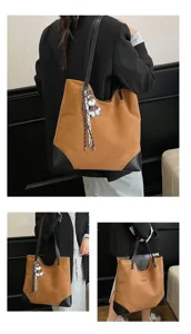Close-up detail of the large suede tote bag showcasing corner leather and cute puppy charm.
