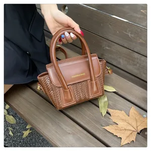 Bolso de mano trenzado marrón con asa superior y correa de hombro elegante chic.