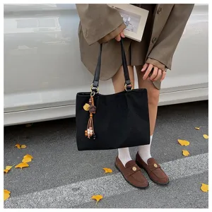 Schwarze Wildleder Umhaengetasche im koreanischen Stil mit Blumenmuster und Quasten Detail.
