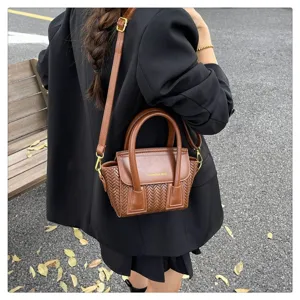 Bolso de hombro tejido marrón, vista detallada con textura exquisita y estilo elegante.