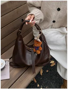 Stylish dark brown PU leather hobo shoulder bag with cute teddy bear charm for women.