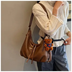 Brown PU leather shoulder bag for women, stylish vintage hobo purse with cute bear pendant.