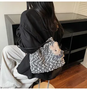 Stylish black and white textured plush shoulder bag for women with cute animal plush pendant.