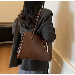 Detailed view of the vintage dark brown leather tote bag, featuring large capacity and chic beads.