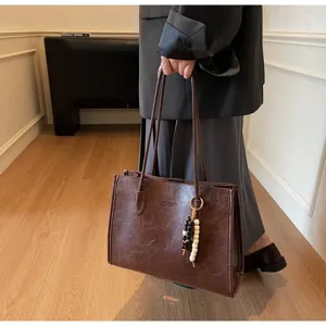 Large capacity retro brown leather tote bag with beaded pendant for daily commuting.