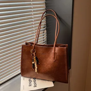Vintage brown leather tote bag for women, large capacity shoulder bag with bead pendant.