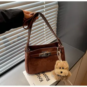Vintage brown suede shoulder bag with classic turn-lock closure and cute plush dog charm.