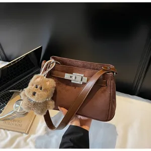 Brown suede Kelly style shoulder bag with cute plush bear pendant, elegant vintage handbag.