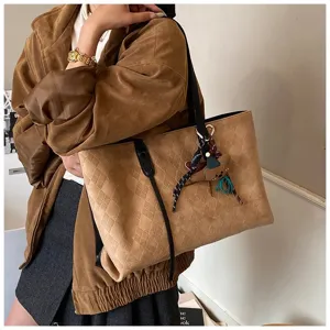 Suede quilted tote bag detail showing soft texture, spacious capacity and black handles.